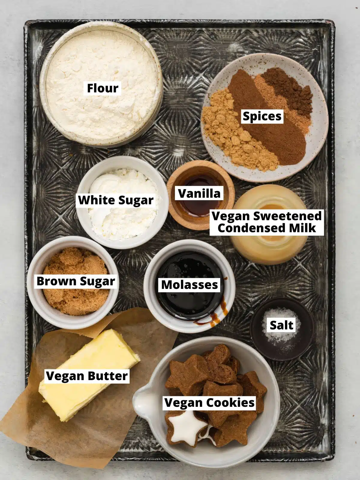 ingredients for ginger caramel slices measured out in bowls on a metal tray.