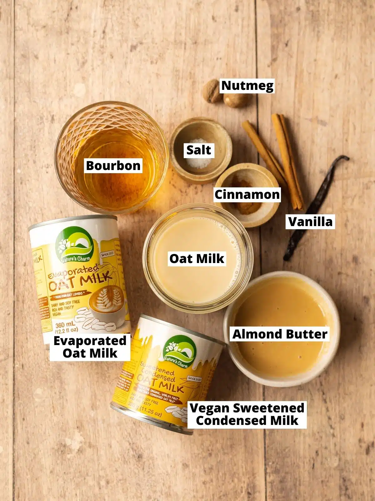 ingredients for oat nog measured out in bowls on a wooden surface.