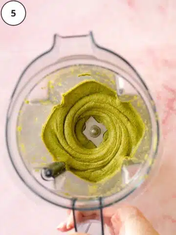 pistachio paste in a blender jug showing the thick and creamy consistency.