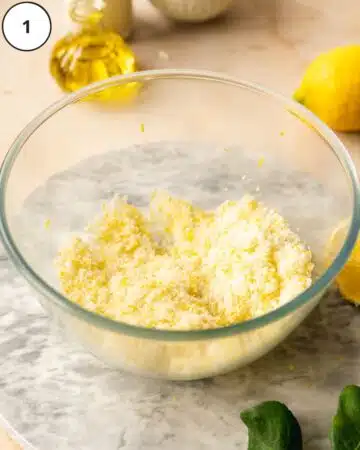 Sugar, lemon zest, and vanilla beans mixed together in a bowl.