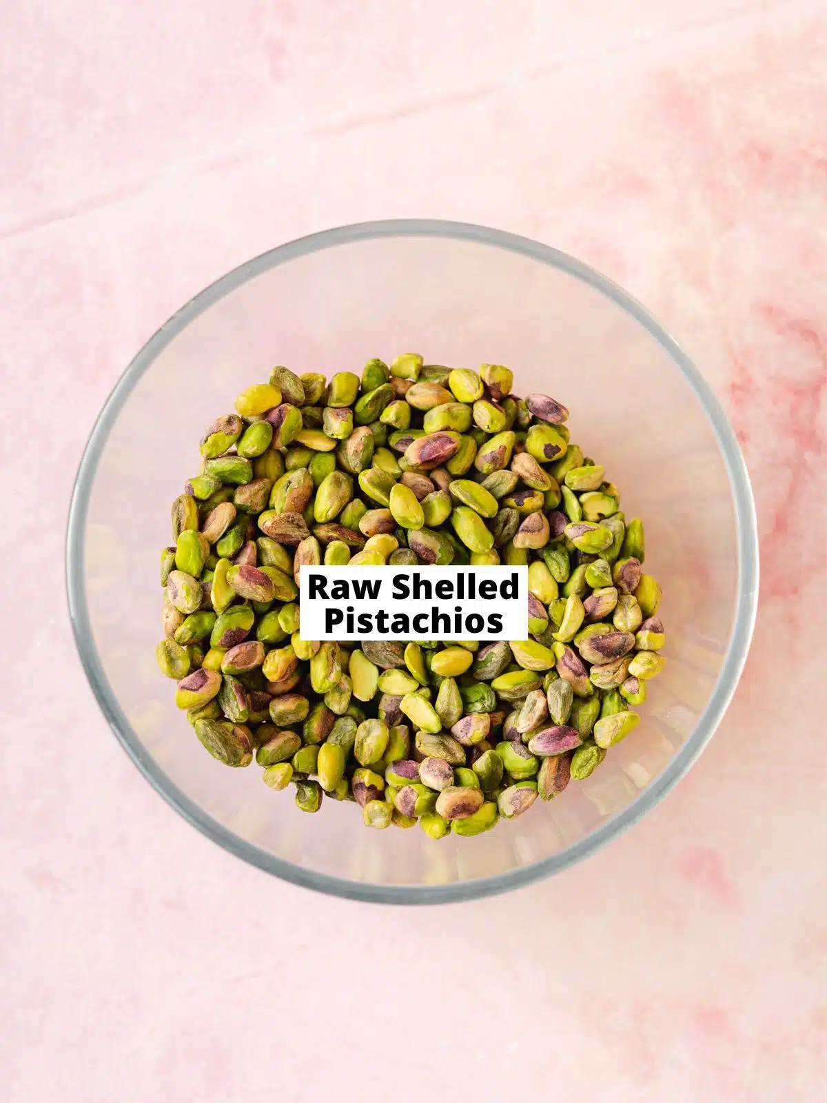 raw shelled pistachios in a large clear bowl.