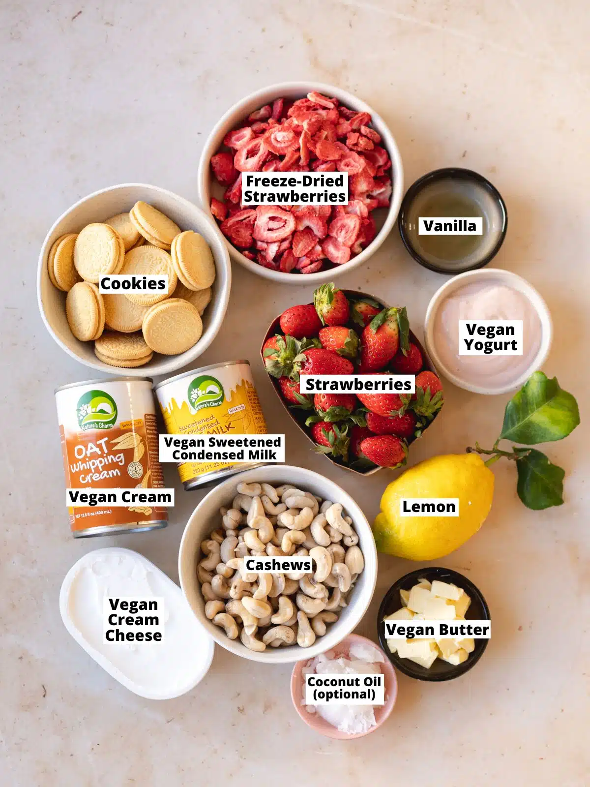 ingredients for vegan strawberry cheesecake measured in bowls on a peach marble surface.