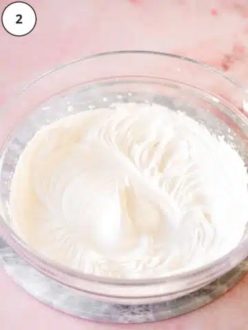 aquafaba whipped to stiff peaks in a large clear bowl.