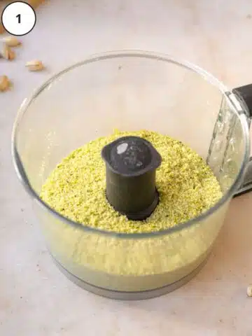 pistachios and sugar ground up in a food processor jug.