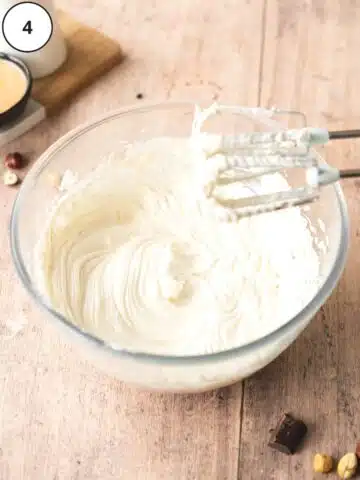 Cream cheese and yogurt mixed together in a clear mixing bowl.