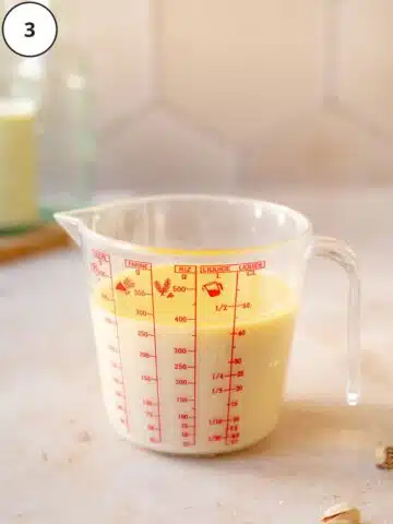 vegan buttermilk and wet ingredients for pistachio cake in a measuring jug.
