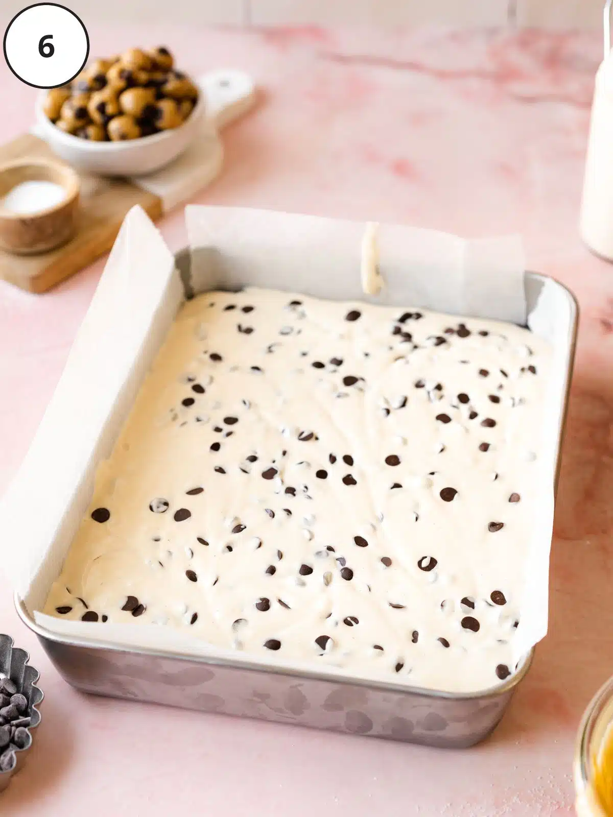 Cheesecake layer poured on top of the cookie dough base and chocolate chips added and swirled in.
