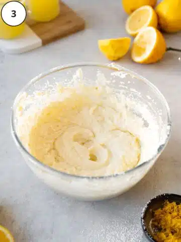 Lemon cheesecake filling in a mixing bowl after whipping in lemon juice, lemon zest, condensed milk, and powdered sugar.