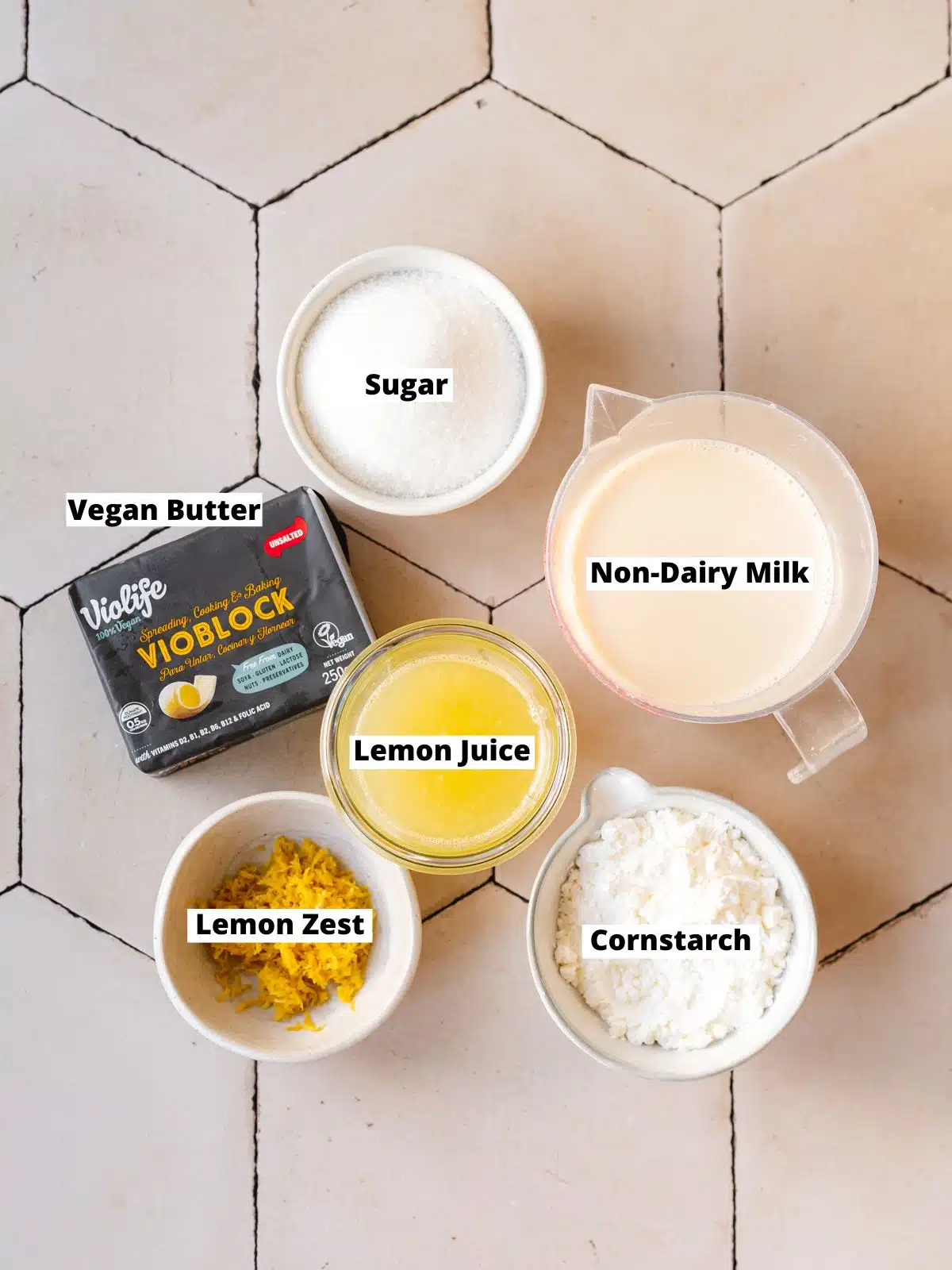 ingredients for vegan lemon buttercream on a tiled surface.