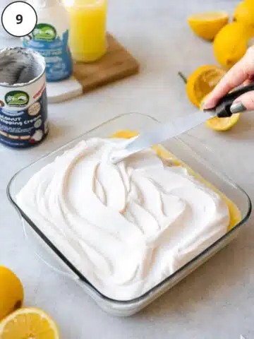 Whipped coconut cream being swooshed over the top of the lemon curd.