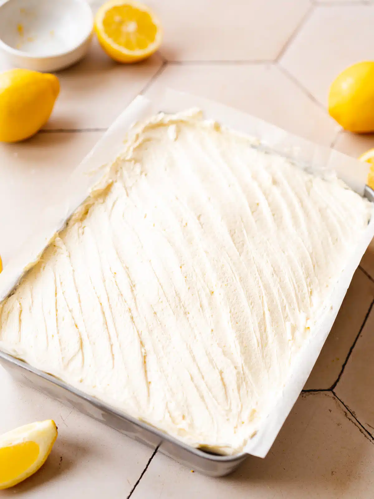 vegan lemon sheet cake with lemon frosting smoothed on top of it showing the smooth and creamy consistency.