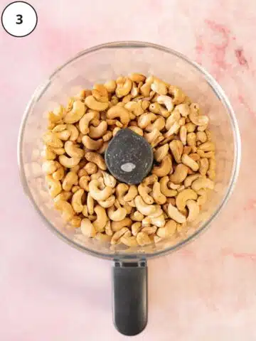 roasted cashews fresh out of the oven in a food processor jug before blending.