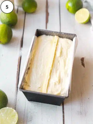 Lime cake batter added to a parchment lined loaf tin and studded with thin pads of butter down the middle length.