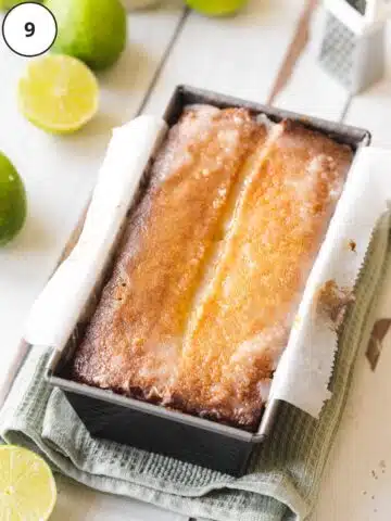 The glaze on the key lime pound cake has firmed up over the 1-hour cooling period, leaving a slightly opaque white color on top of the cake in the pan.