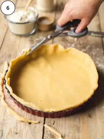 cutting around the edges of pastry of a tart.