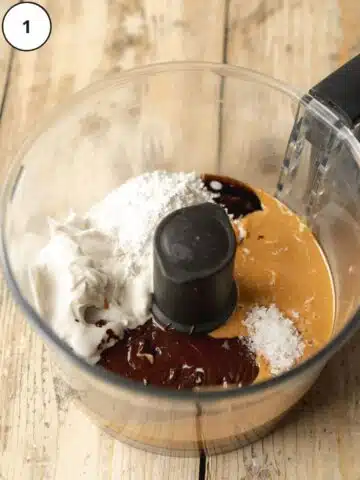 All ingredients for making homemade dairy-free Nutella added to the base of a food processor equipped with the blade attachment.