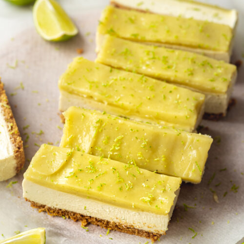several slices of no-bake cheesecake bars with a creamy filling and vibrant green lime curd topping.