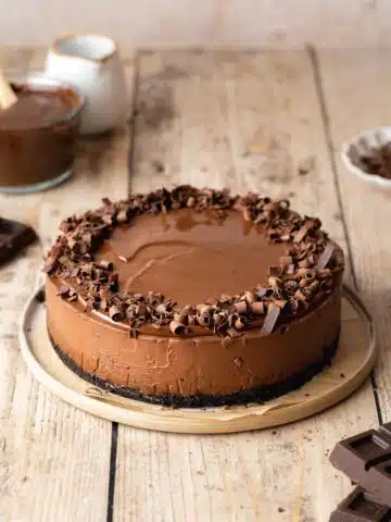 No bake vegan chocolate cheesecake garnished with a ring of chocolate curls.