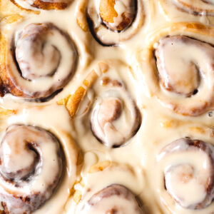 Closeup overhead shot of vegan cinnamon rolls with a thick dairy-free vanilla glaze.