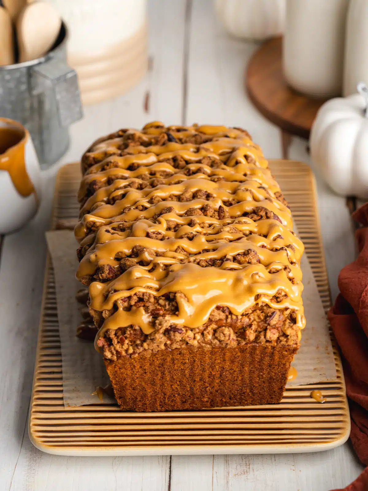 fluffy vegan pumpkin bread on a cutting board. It has a streusel topping and a few slices taken from it.