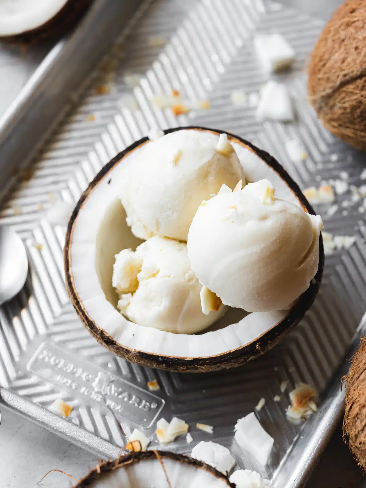 three scoops of coconut sorbet served in a fresh coconut shell.