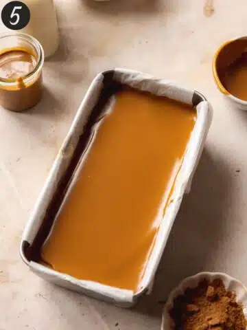 Layer of biscoff cookie spread poured and smoothed over the refrigerated pumpkin cheesecake layer.