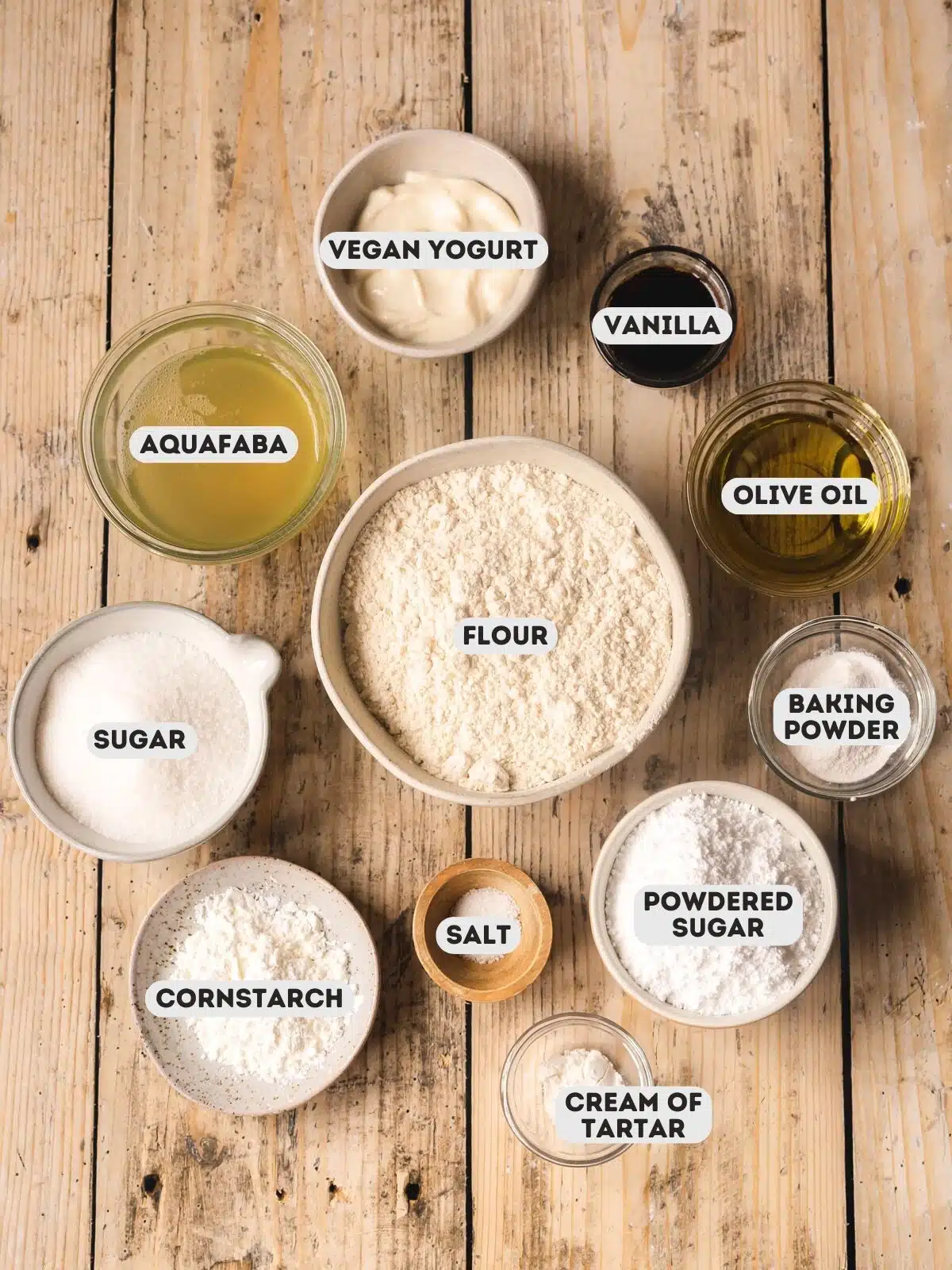 ingredients for homemade vegan savoiardi measured out in bowls on a wooden surface.
