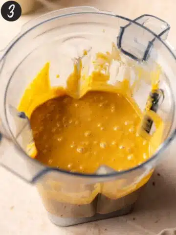 Vegan pumpkin cheesecake mixture in the base of a blender after blending to creamy perfection.