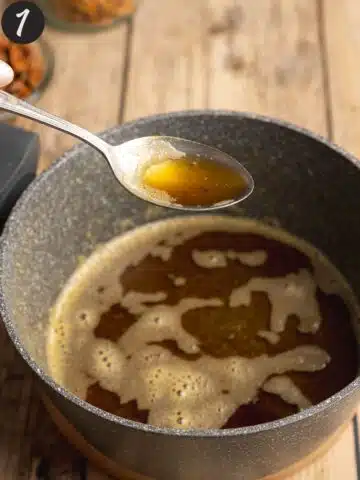 Browned butter in a saucepan with a silver spoon taking some out to show the deep golden brown color.