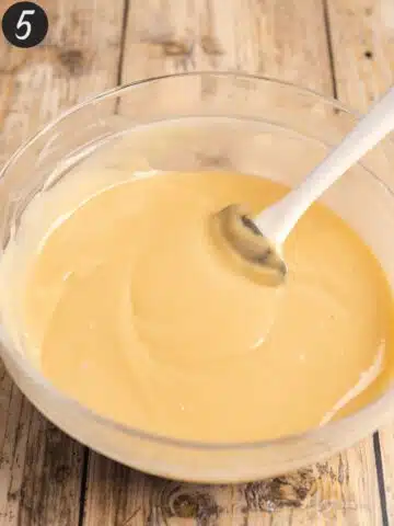 a thick custard with vegan butter mixed through in a large clear mixing bowl.