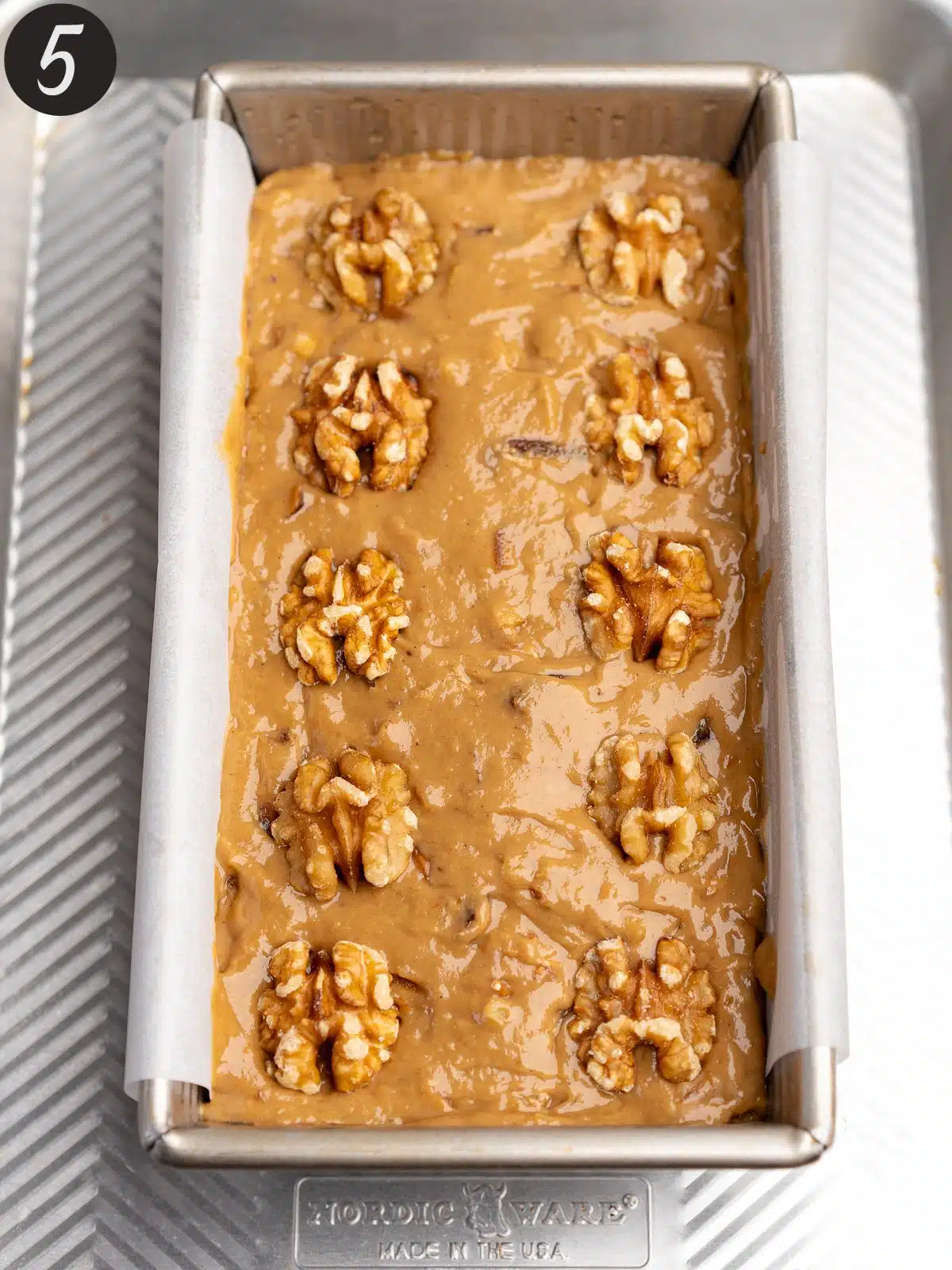 date cake studded with walnuts in a loaf pan before baking.