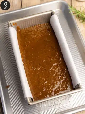 gingerbread cake batter in a metal USA loaf pan.