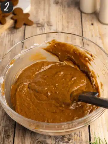 gingerbread cake mix mixed together in a large clear bowl with a spatula.