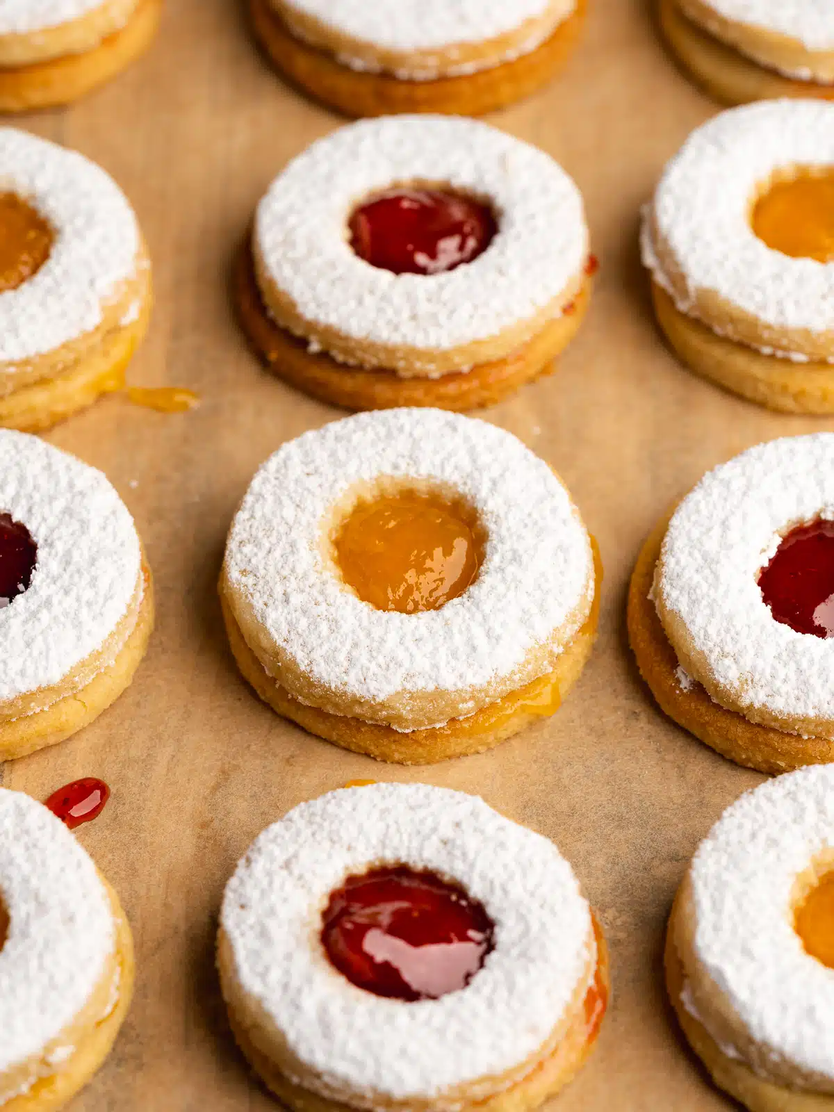 rows of jam and marmalade filled linzer cookies.