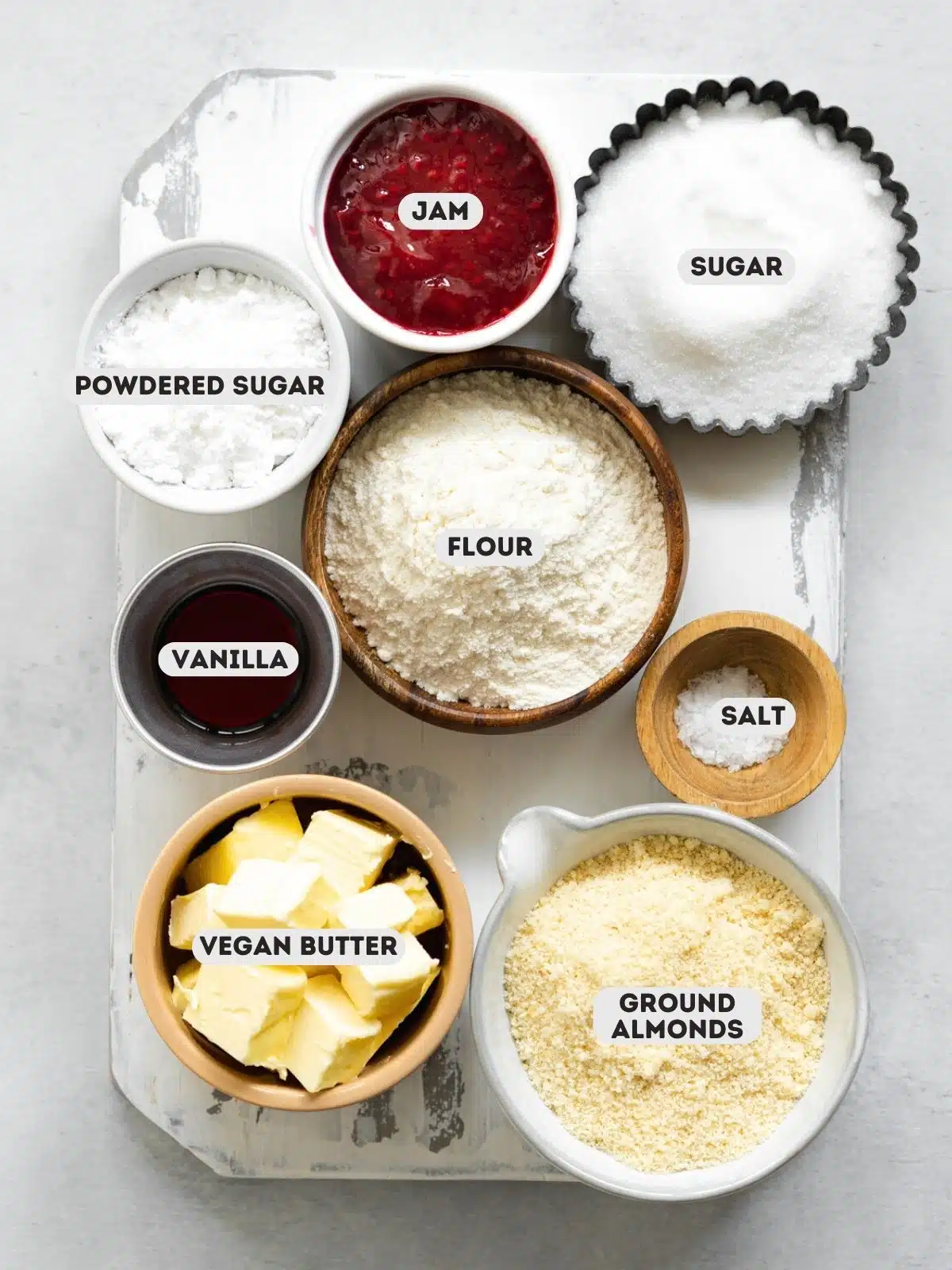 ingredients for linzer cookies measured out in bowls with text overlay.