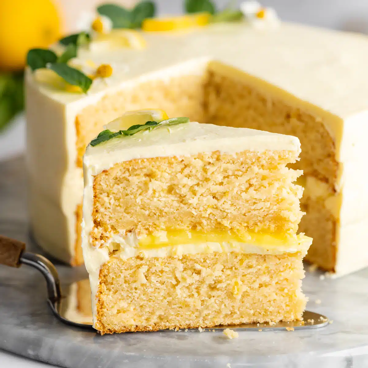 a slice of vegan lemon cake with lemon curd filling.