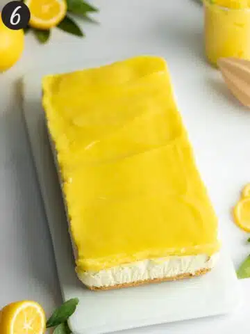 a rectangular lemon cheesecake on a white plate being being cut into slices.