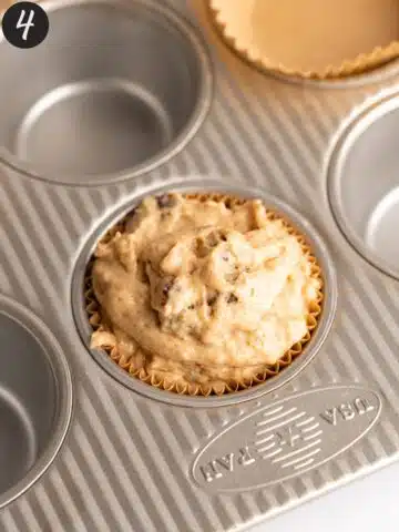 a muffin pan with every second well packed with date muffin batter.