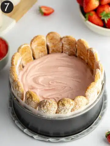 a layer of vegan strawberry mousse on top of the strawberry pieces in a cake pan.