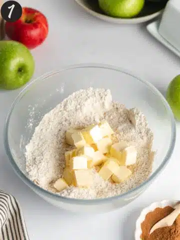 dry ingredients in a bowl with room temperature butter chunks.
