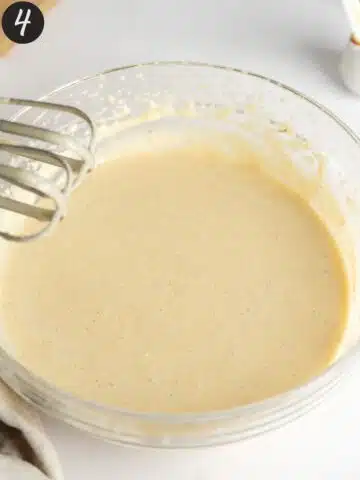 wet ingredients for vanilla cake mixed in a large clear bowl.
