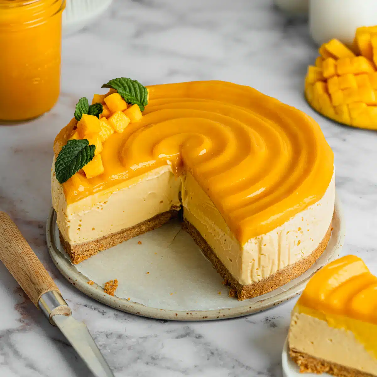 a mango cheesecake with curd topping swirled on top and a few slices taken from it.