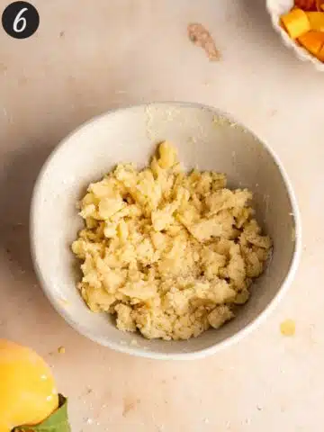 sugar crumble for peach muffins in a small ceramic bowl.