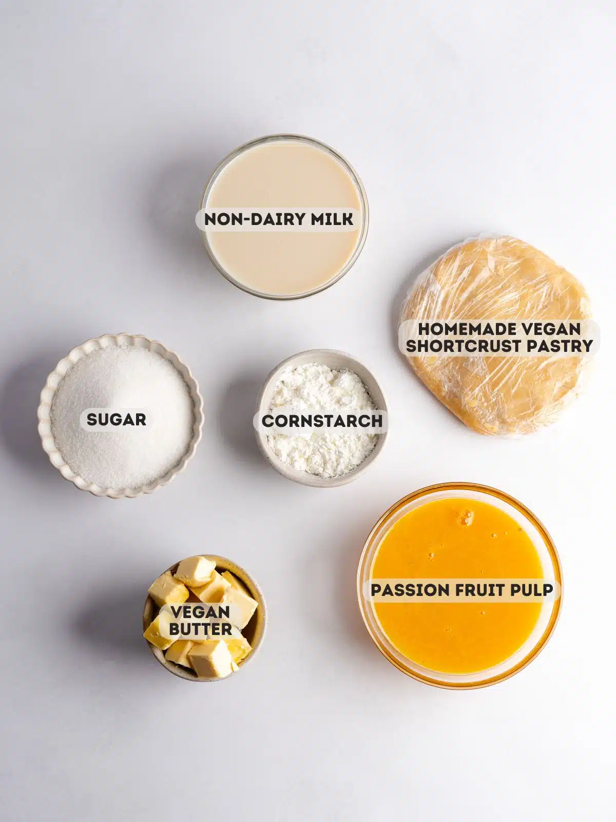 ingredients to make vegan passionfruit tart measured out in bowls on a gray surface.