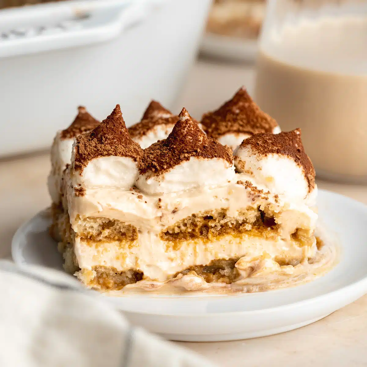 a slice of vegan baileys tiramisu on a small white plate.