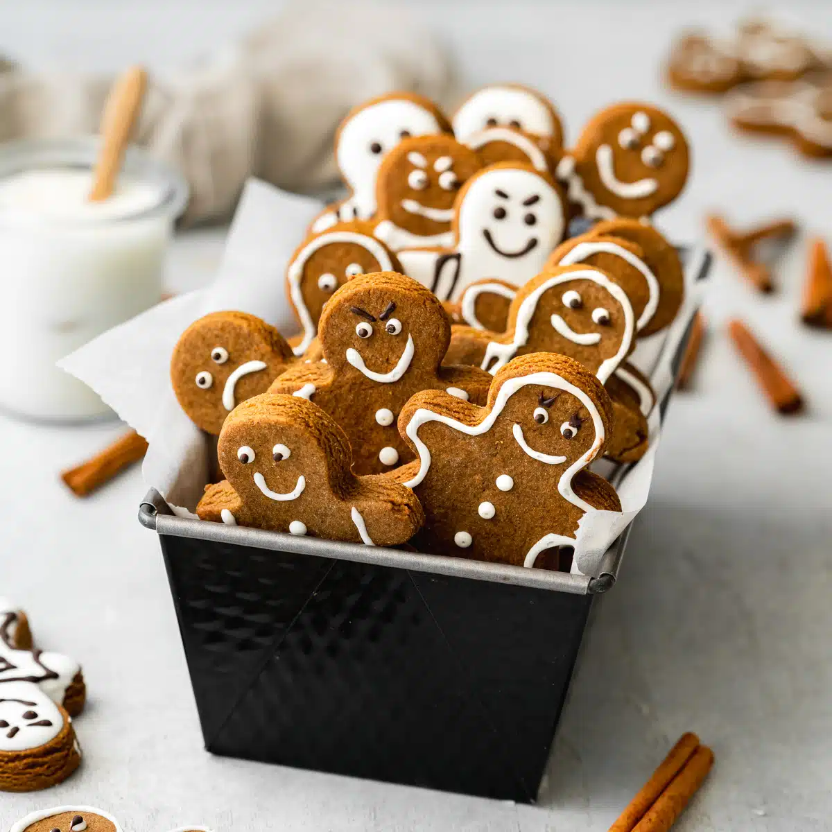 vegan gingerbread cookies with different expressions in a loaf pan.